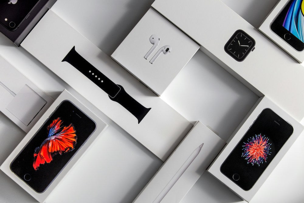 apple watch, airpods and iphones in brand new boxes laid out 